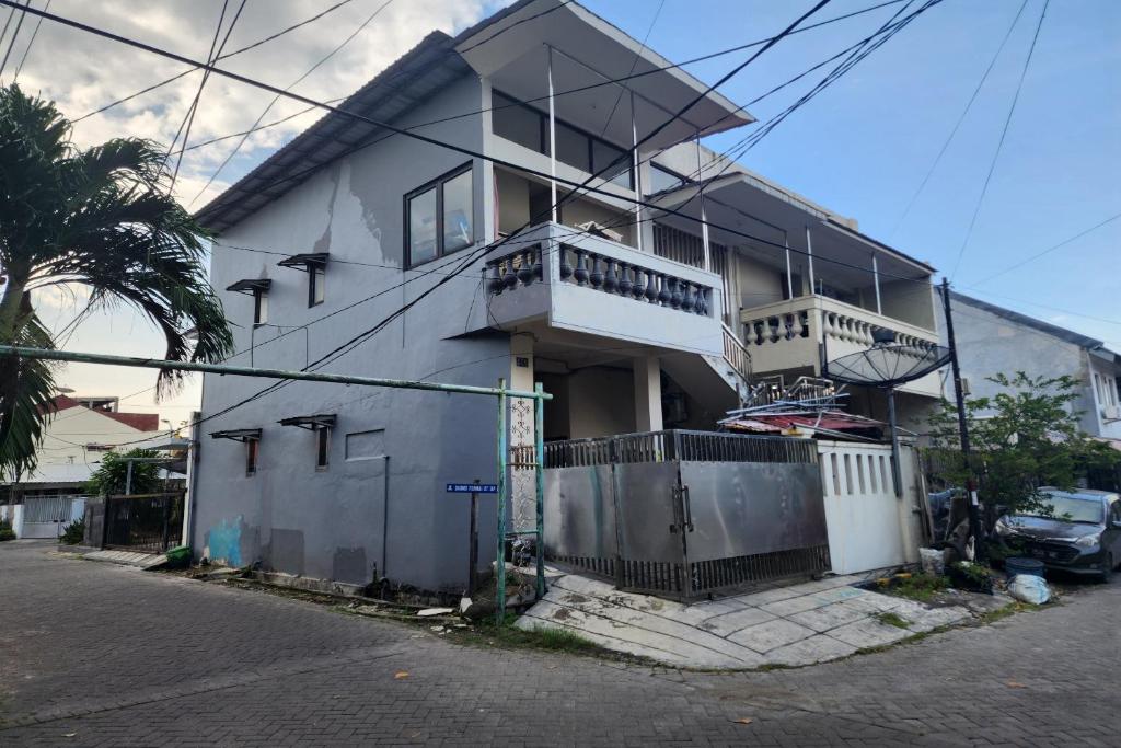 泗水OYO 93865 Dv Homestay Syariah Kupang的前面有栅栏的白色房子