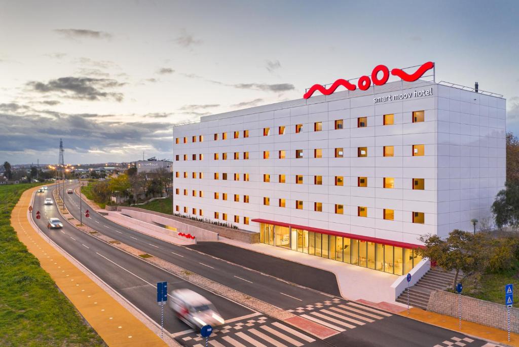 奥埃拉斯Moov Hotel Oeiras的高速公路旁的一座建筑,上面有公里标志
