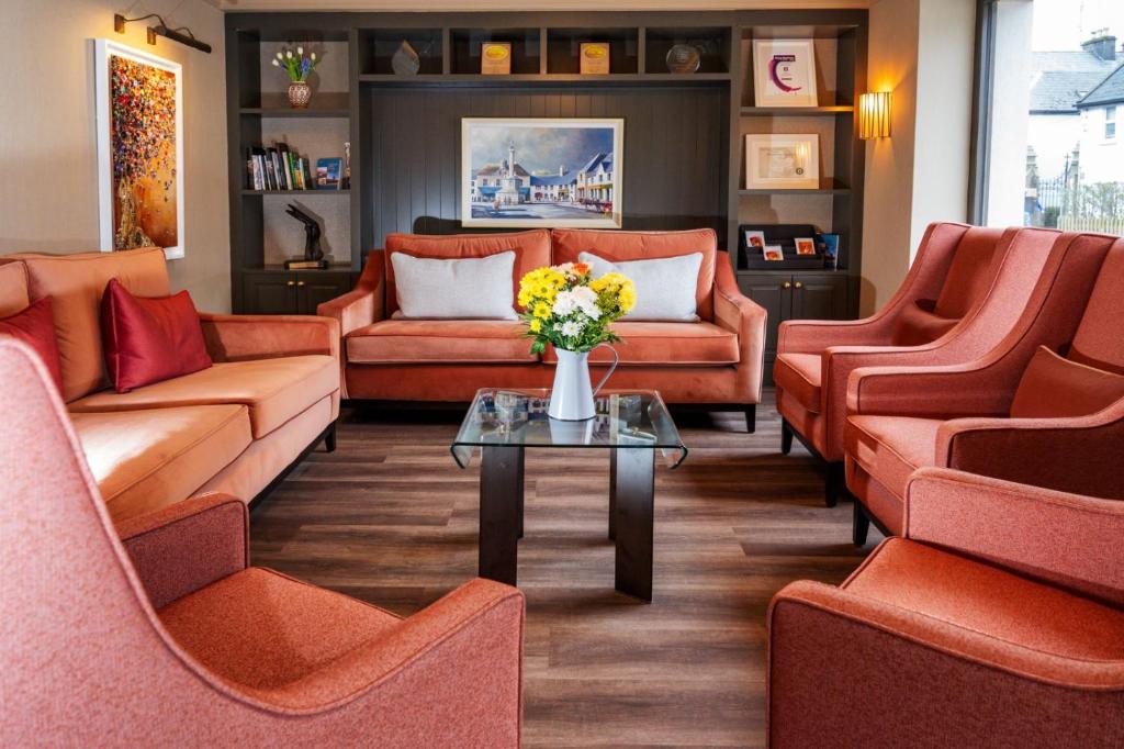 韦斯特波特克鲁尔海湾酒店的一间设有橙色沙发和鲜花桌的等候室