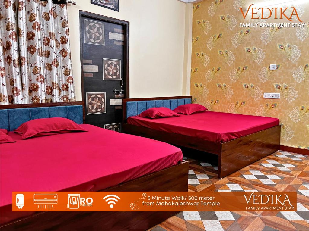 乌贾因Vedika Yatri Grah - Entire Apartment的红色床单的客房内的两张床