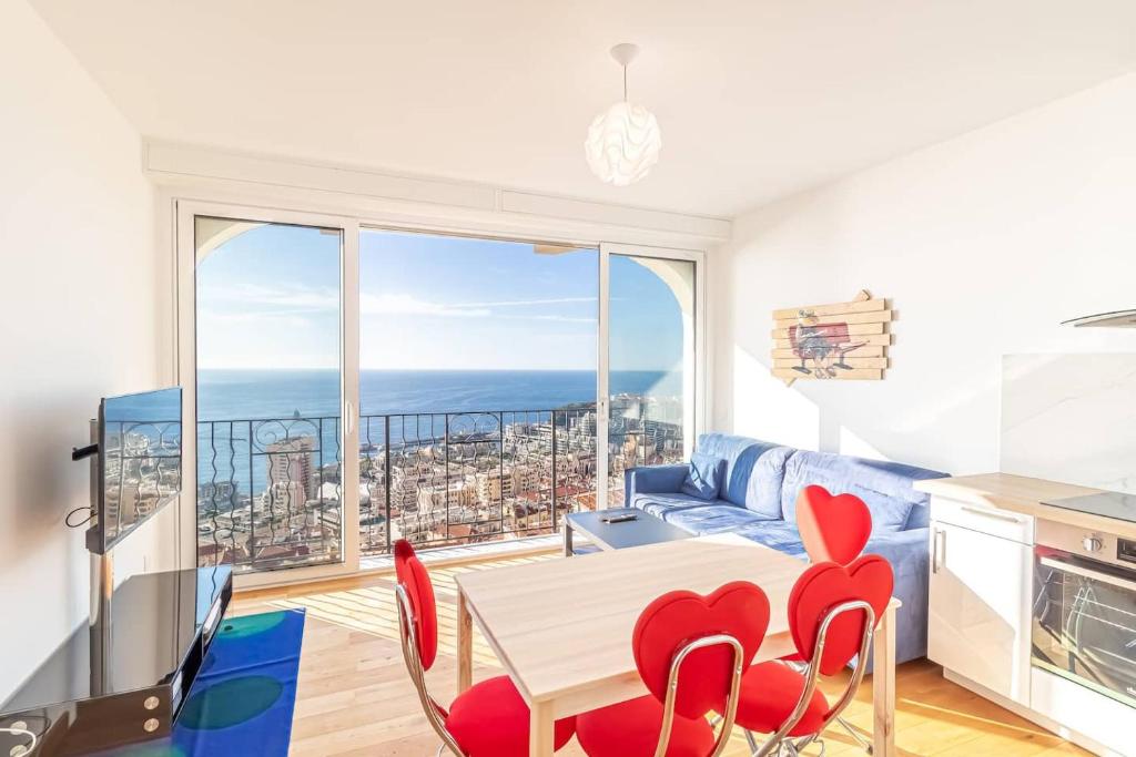 博索莱伊Amazing Sea View T2- Near Monaco的客厅配有桌椅和大窗户