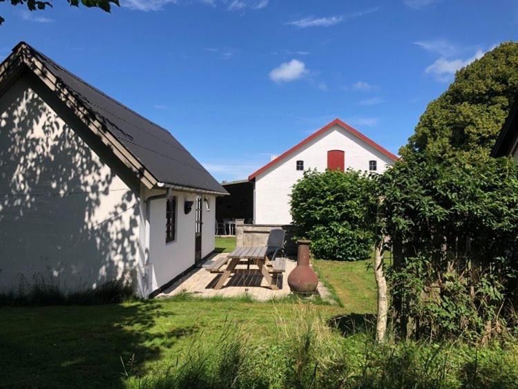 Uggerby桑德加德农家乐的一间白色的房子,有红色的门和一个院子