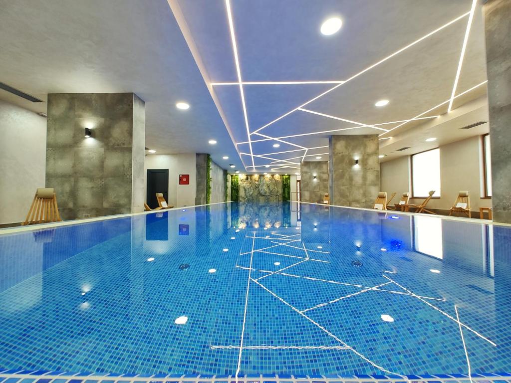 兹拉蒂博尔Velika Recepcija CC Magnet的一座铺有蓝色瓷砖地板的大型游泳池