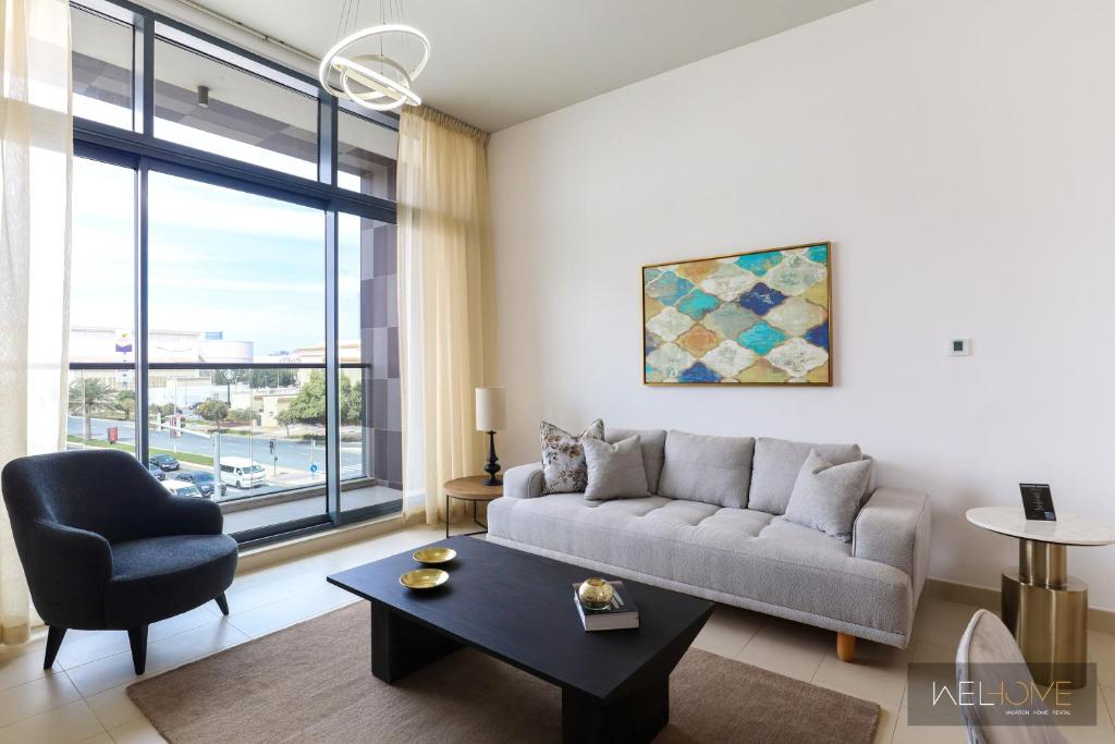迪拜WelHome - Prime 1BR Apartment at Oia Residence的客厅配有沙发和桌子