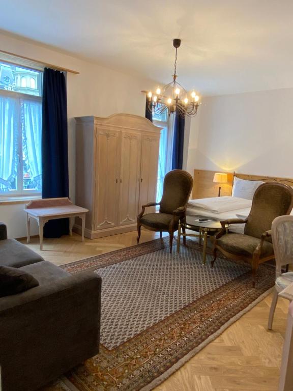 因特拉肯Carlton-Europe Vintage Adults Hotel的客厅配有沙发、椅子和桌子