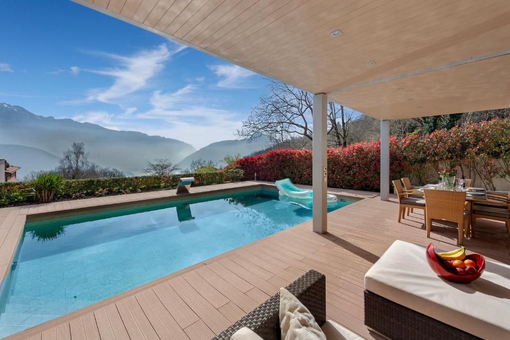 卢加诺Villa Dolce Vita With Private Pool - Happy Rentals的后院的游泳池,配有桌椅