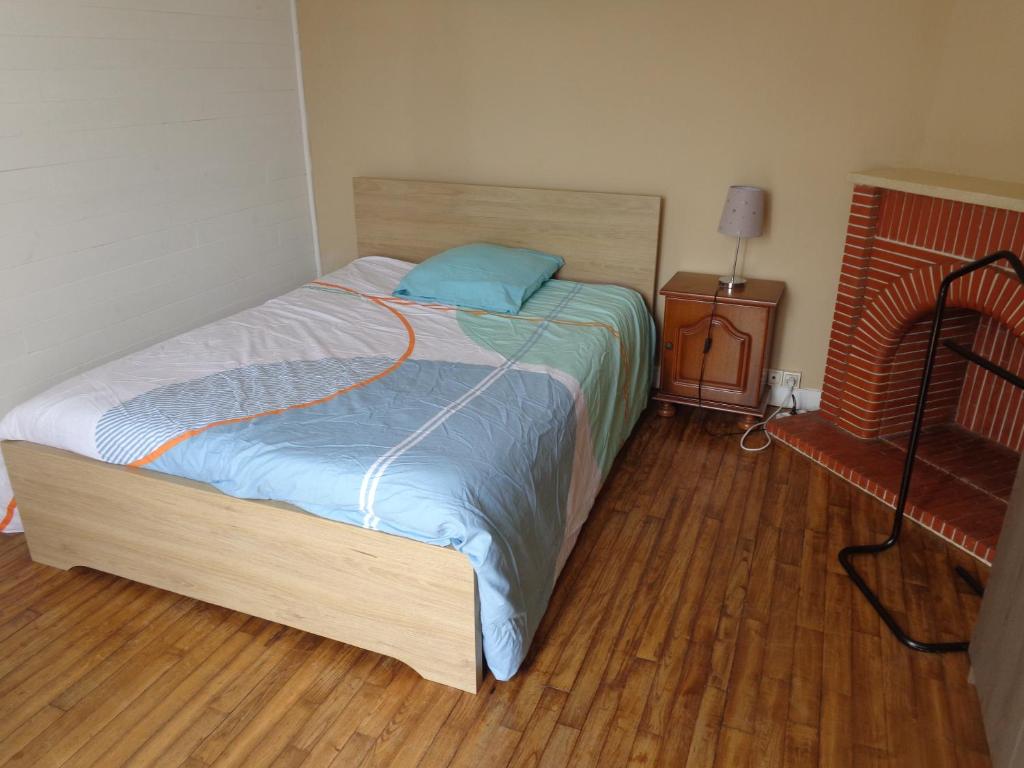 QuestembertChambre chez l'habitant的卧室内的一张床位,铺有木地板