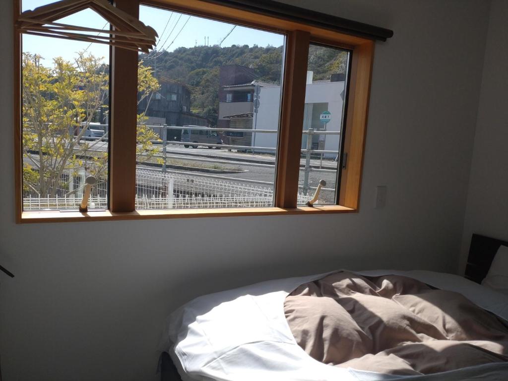 直岛町Naoshima Accommodation Menjuku Ura - Vacation STAY 25585v的一间卧室设有一张床和一个美景窗户。