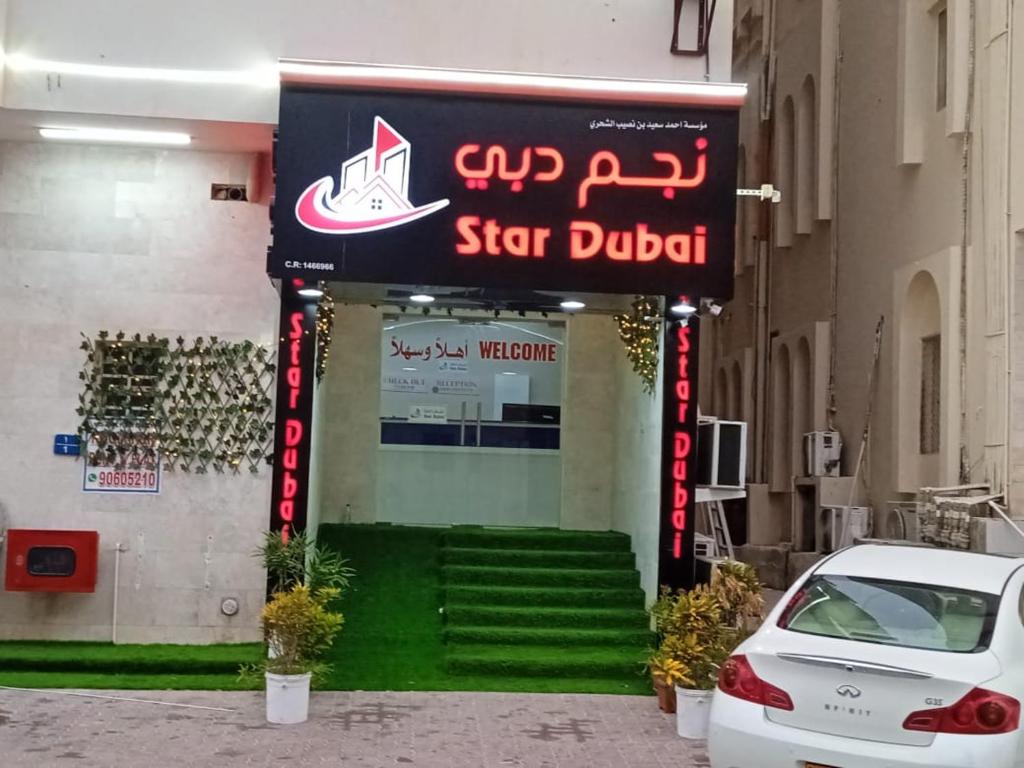 塞拉莱Star Dubai Apartment的停在商店标志前的汽车