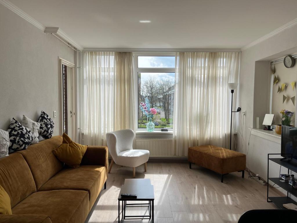 皮尔默伦德Lovely and spacious apartment in Purmerend的带沙发、椅子和窗户的客厅