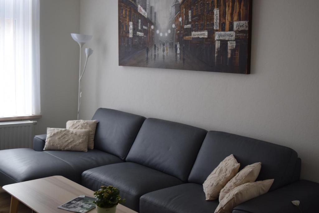 伊普尔极光公寓的客厅配有蓝色的沙发和桌子