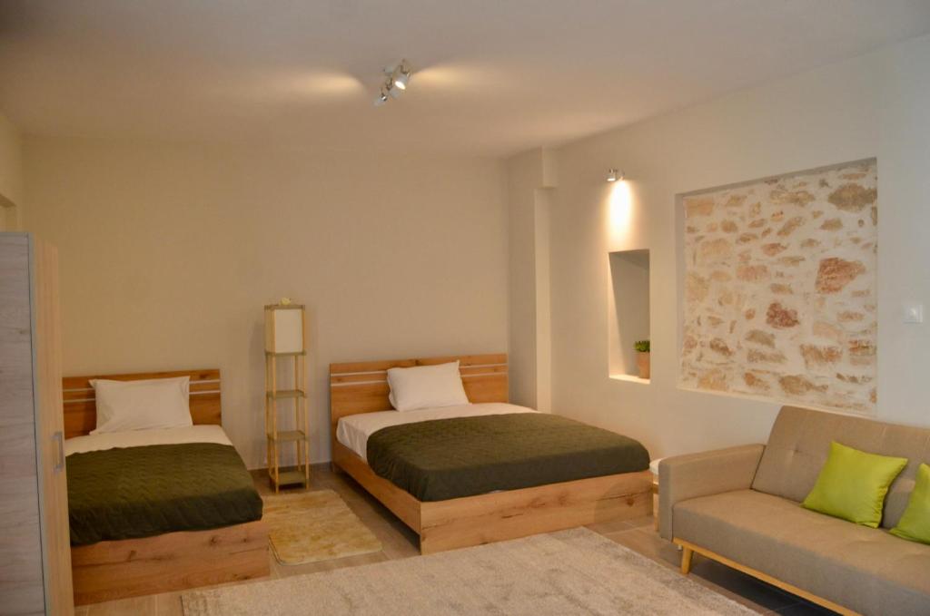 PaianíaHarihara Guesthouse的一间卧室配有两张床、一把椅子和一张沙发