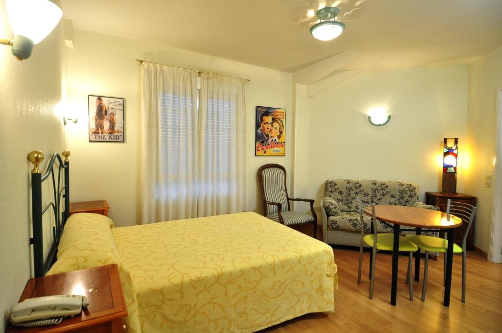 拉拉斯特里拉阿罗索蒂略公寓式酒店的卧室配有1张床、1张桌子和1把椅子