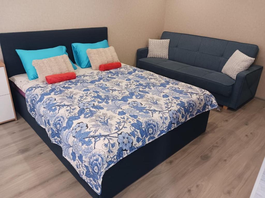 陶格夫匹尔斯Kandavas Apartments的一张带蓝色和白色毯子的床和一张沙发