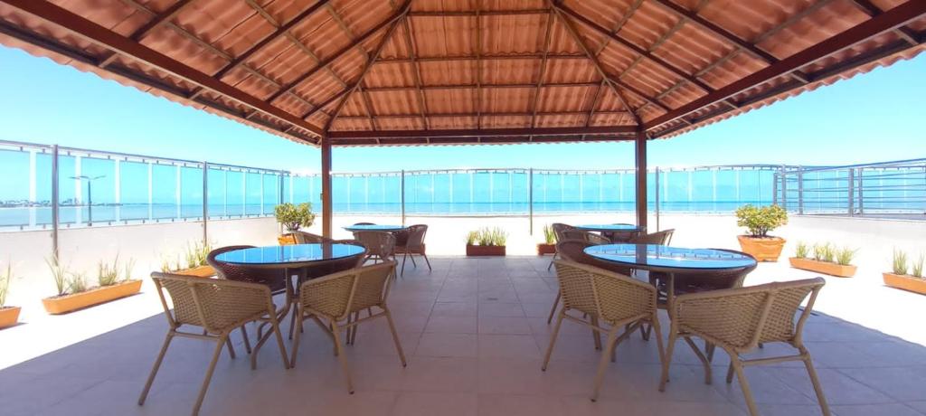 若昂佩索阿Flat Manaíra Palace Beira Mar的一个带桌椅的庭院和海滩