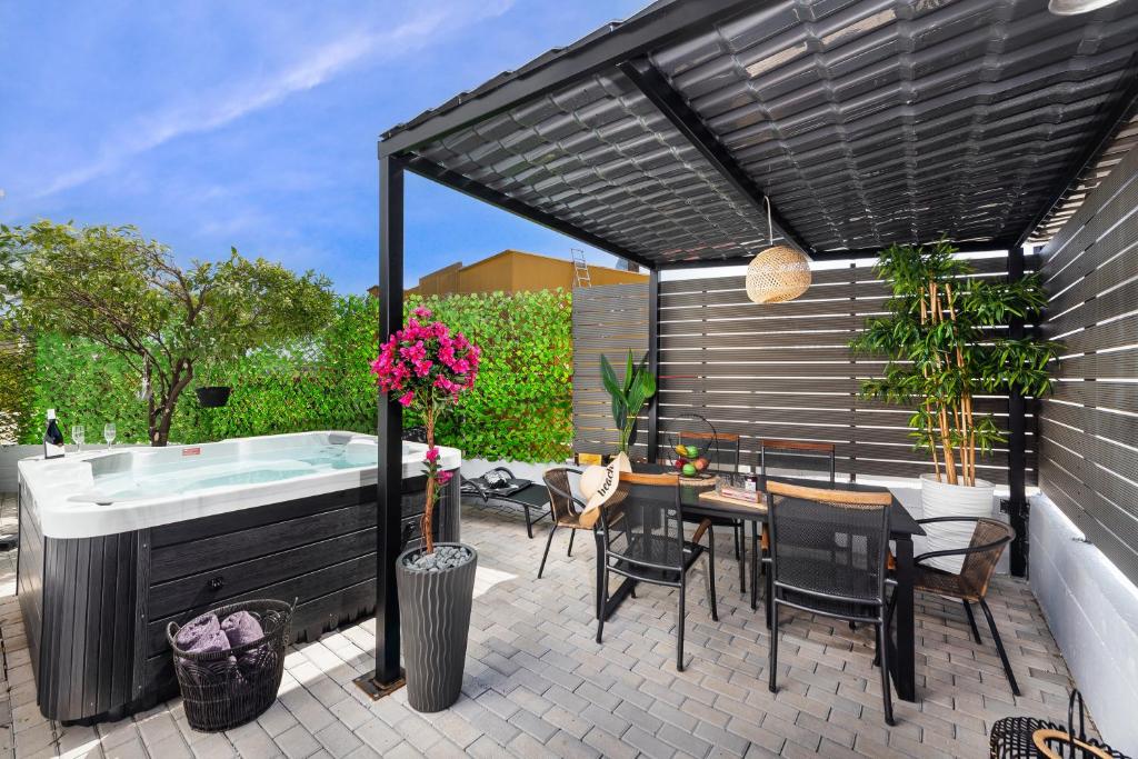 阿凡杜Evi's Afandou Suite的庭院设有热水浴池、桌子和椅子。