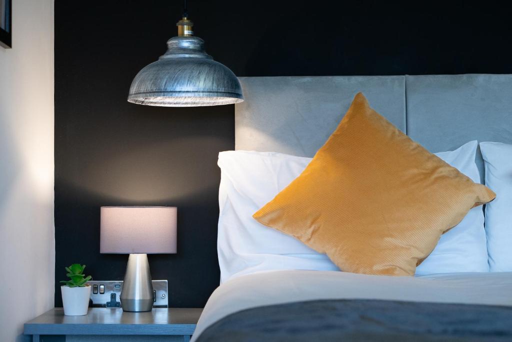 彼得伯勒Midsummer Apartments "Free On-Site Parking & Sky TV"的一间卧室配有一张带枕头和灯的床