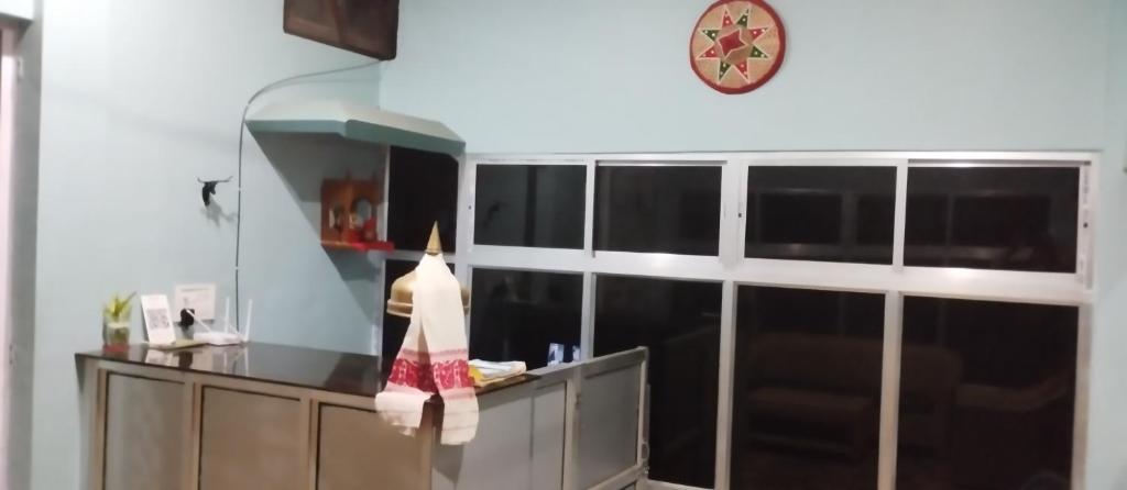 卡齐兰加MONIRAMS INN.的厨房配有柜台和墙上的时钟