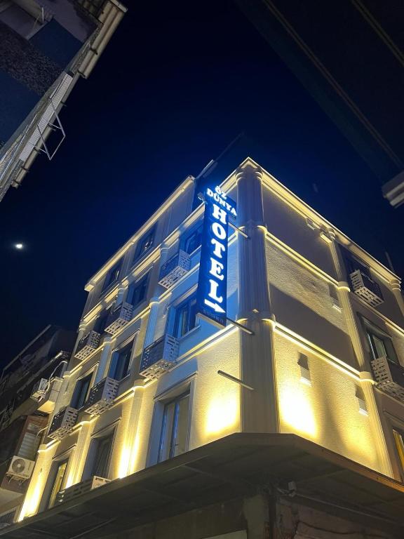 伊斯坦布尔Öz Dünya Hotel的夜间大楼一侧的酒店标志