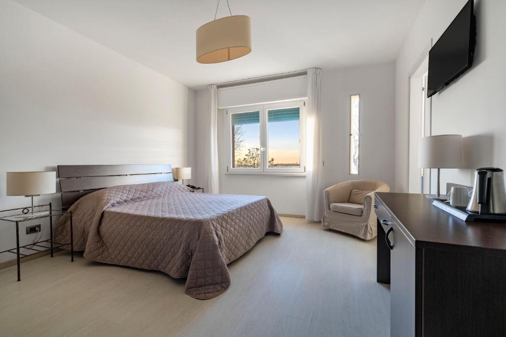 威尼斯丽都索瑞索酒店的一间卧室配有一张床、一张书桌和一个窗户。
