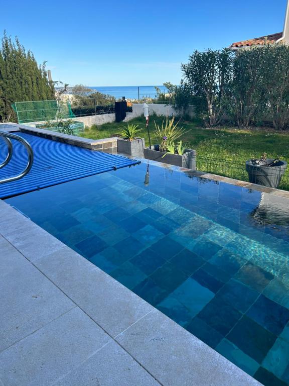 尼斯COTTAGE MARIN avec VUE MER的后院的蓝色瓷砖游泳池