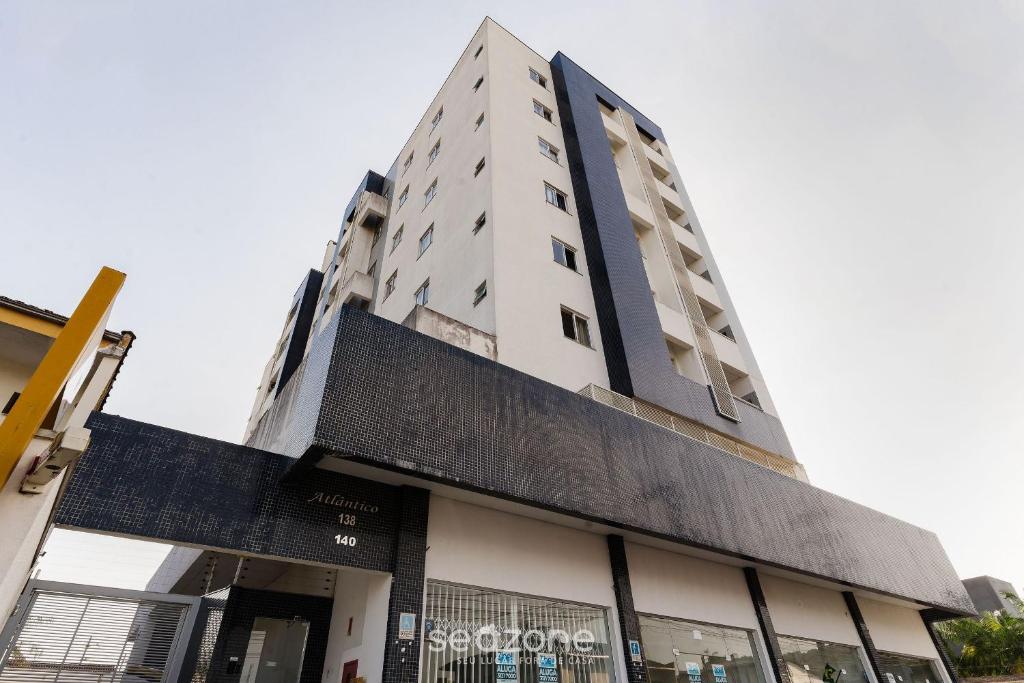 约恩维利EAO - Apartamentos completos em Joinville/SC的一座高大的白色建筑,有很多窗户