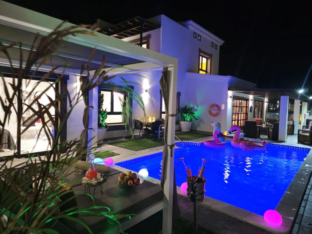 普拉亚布兰卡VILLA KARLA的一座晚上设有游泳池的房子