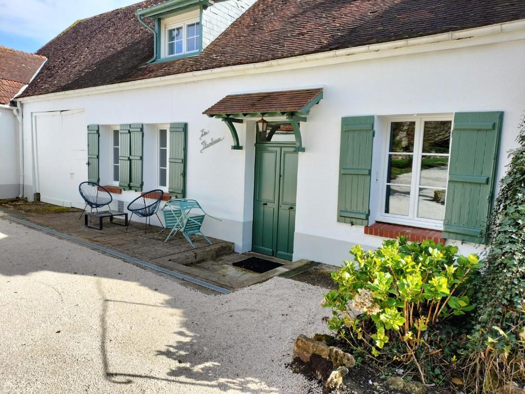 Mareuil-en-BrieCharmant gîte : Les flambeaux的白色的房子,配有绿色百叶窗和桌椅