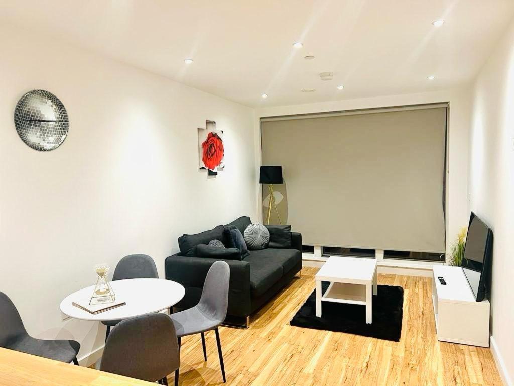 吉林汉姆A Cosy 2bedroom Apartment With River View的客厅配有黑色沙发和桌子