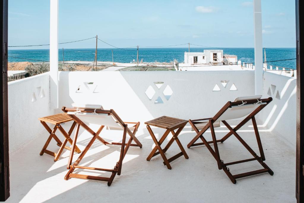 斯基罗斯岛HORIZON Skyrian house的阳台上配有两把椅子和一张桌子,享有海景