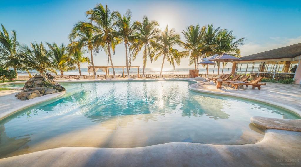 圣布拉斯Hotel Bahía Paraíso的度假村内棕榈树游泳池