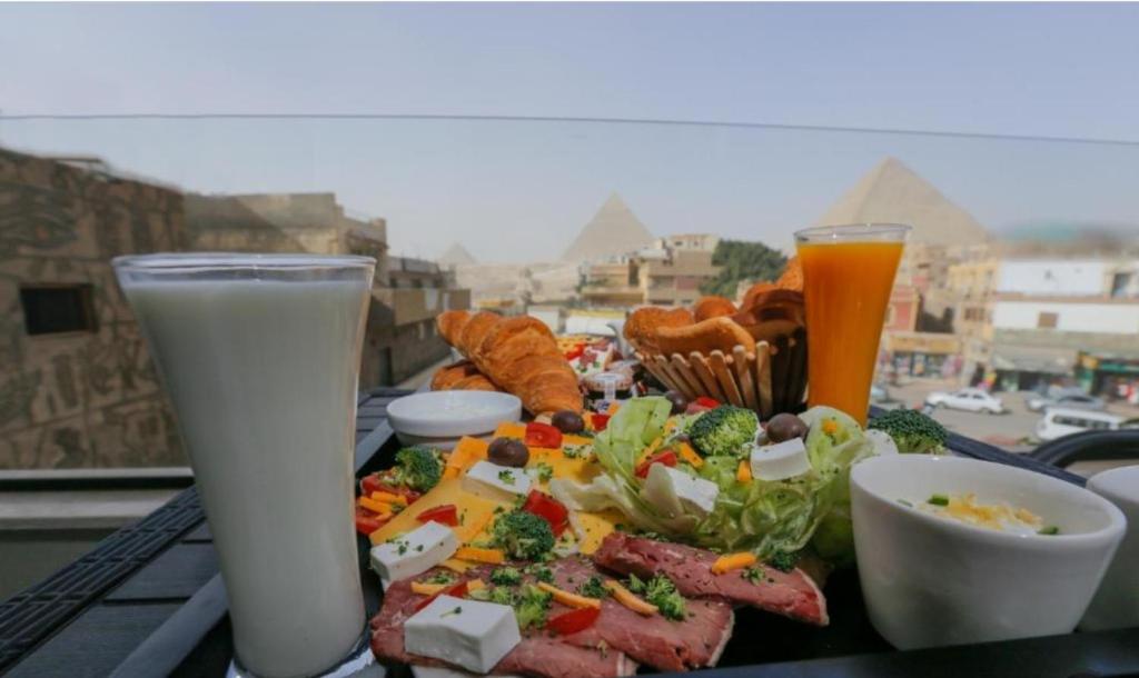 开罗Pharaonic Pyramids Inn的一张桌子,上面放着一盘食物和两杯牛奶