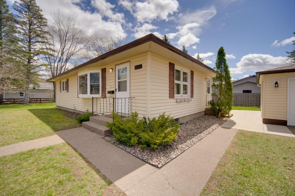 克洛凯Sunny Cloquet Home - 2 Mi to St Louis River!的一座小黄色房子,有草地庭院