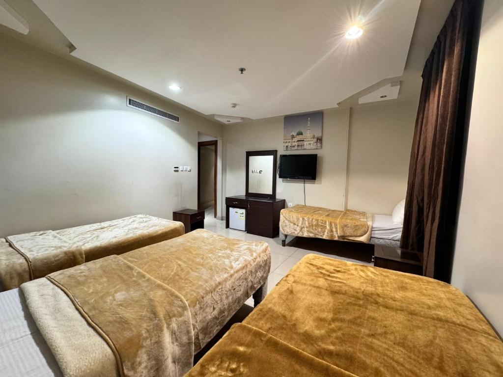 Az Zahrāʼكريستال التاج ٢的酒店客房设有两张床和一台平面电视。