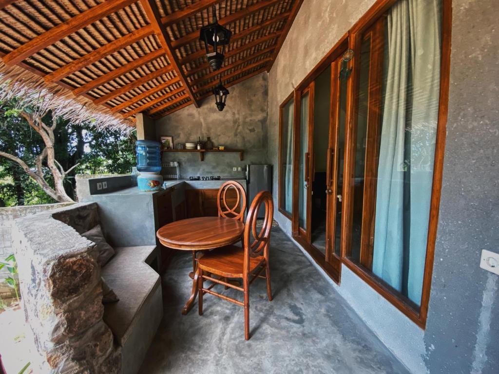 卡里蒙贾瓦Basa-basi Lodge的门廊上摆放着一张桌子和两把椅子
