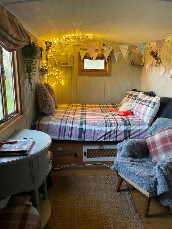 惠特比Oakley View Shepherds Hut with hot tub的一间设有两张床和一张沙发的房间