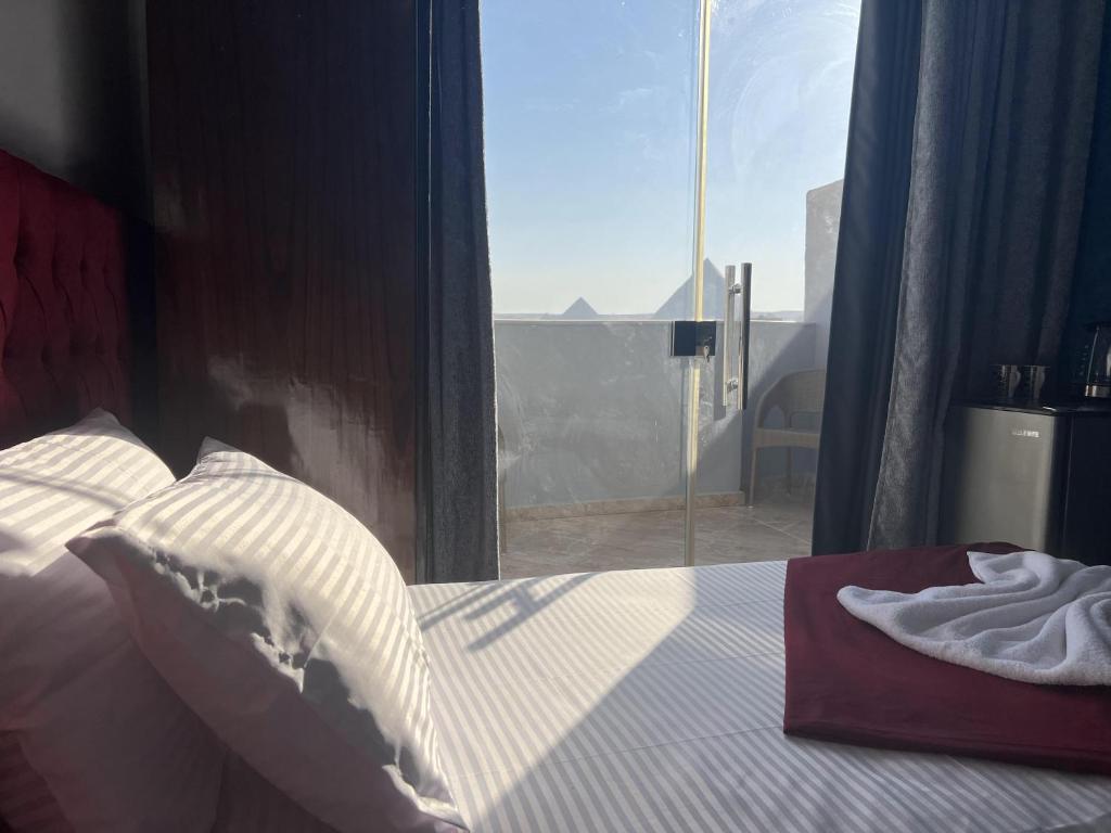 开罗Orion pyramids view的一间卧室设有一张床和一个大窗户