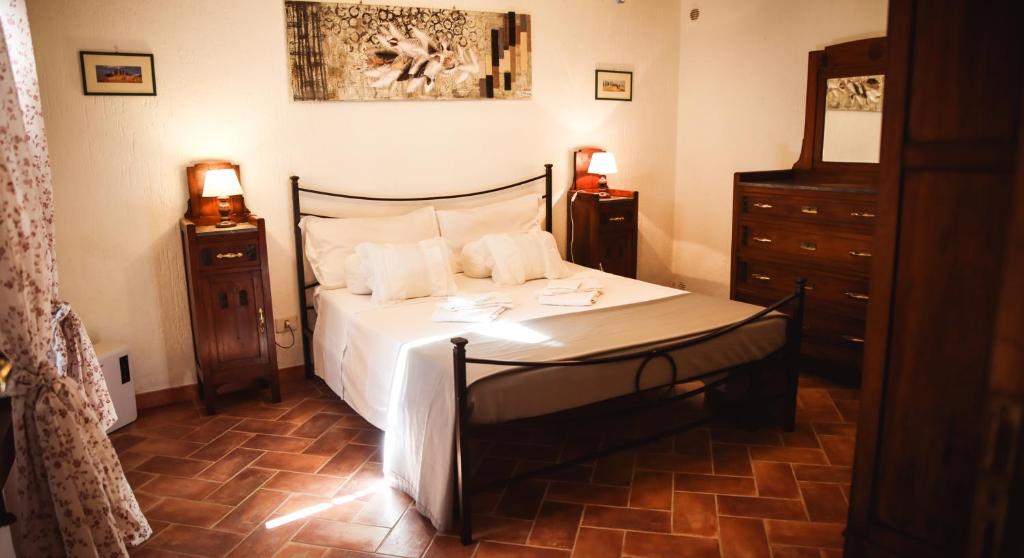 罗卡斯特拉达Nature & Relax in Tuscany - Fresco 2的一间卧室配有白色床单和2个床头柜