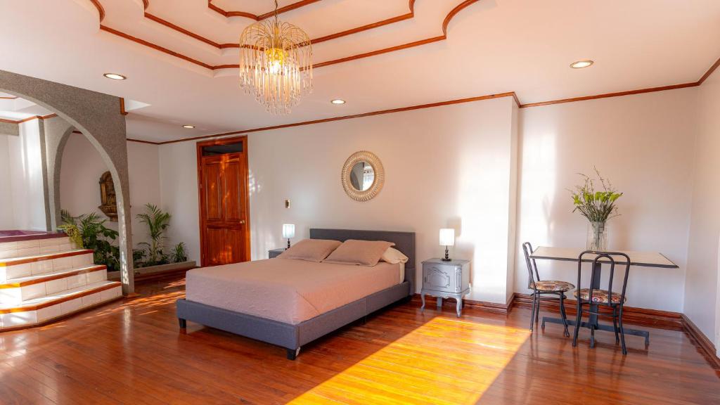 埃雷迪亚海龟家族住宿加早餐旅馆的一间卧室配有一张床、一张桌子和一个吊灯。