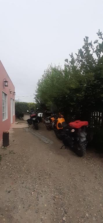 克曼丹特鲁斯皮耶德拉布纳Hospedaje PIEDRA BUENA的停在房子旁边的一群摩托车