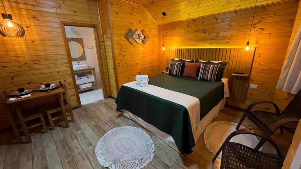 蒙特韦尔迪Chalés Canto da Serra的小木屋内一间卧室,配有一张床