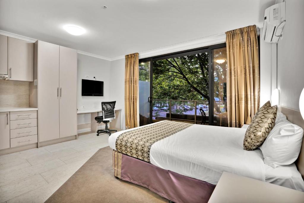 墨尔本Carlton Lygon Lodge - Close to Melbourne Uni的一间卧室设有一张床和一个大窗户