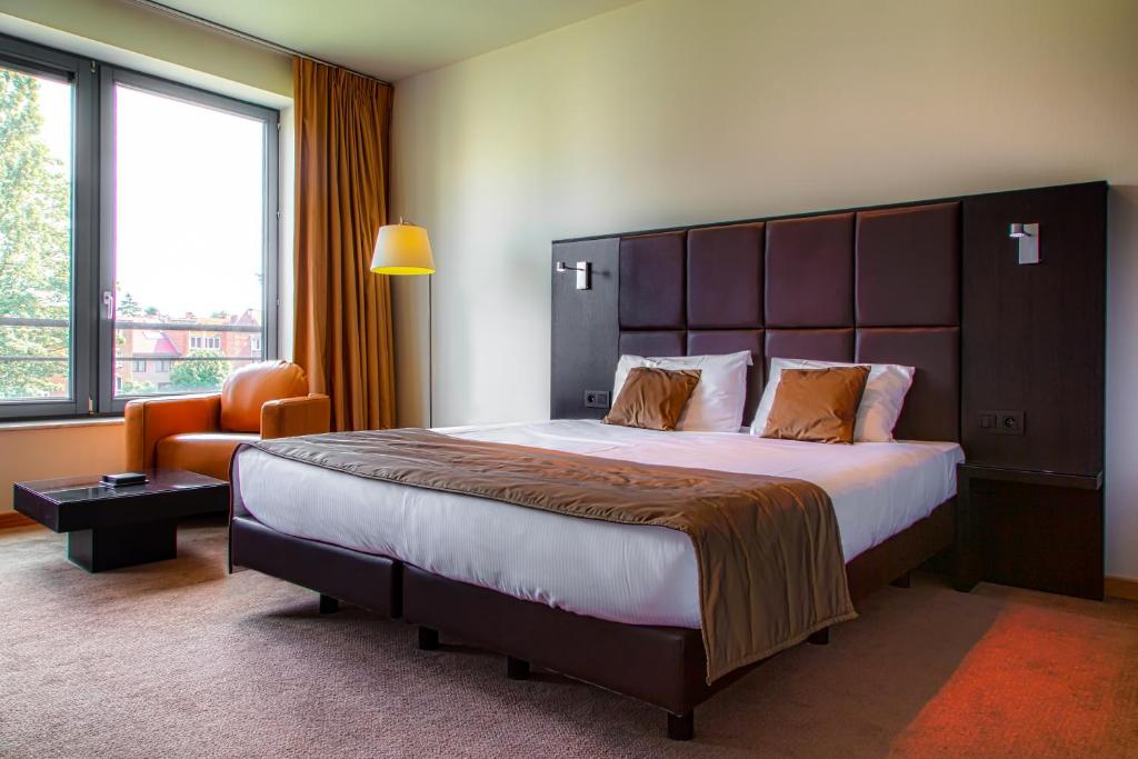 布鲁塞尔布鲁塞尔EU钻石套房公寓的酒店客房带一张大床和一把椅子