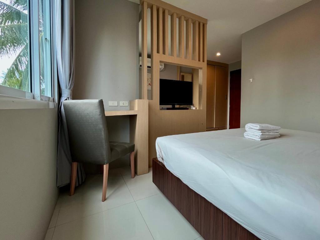 Ban Khlong HaengHidayah Condotel,Ao-nang, Krabi的一间卧室配有一张床、一张桌子和一把椅子