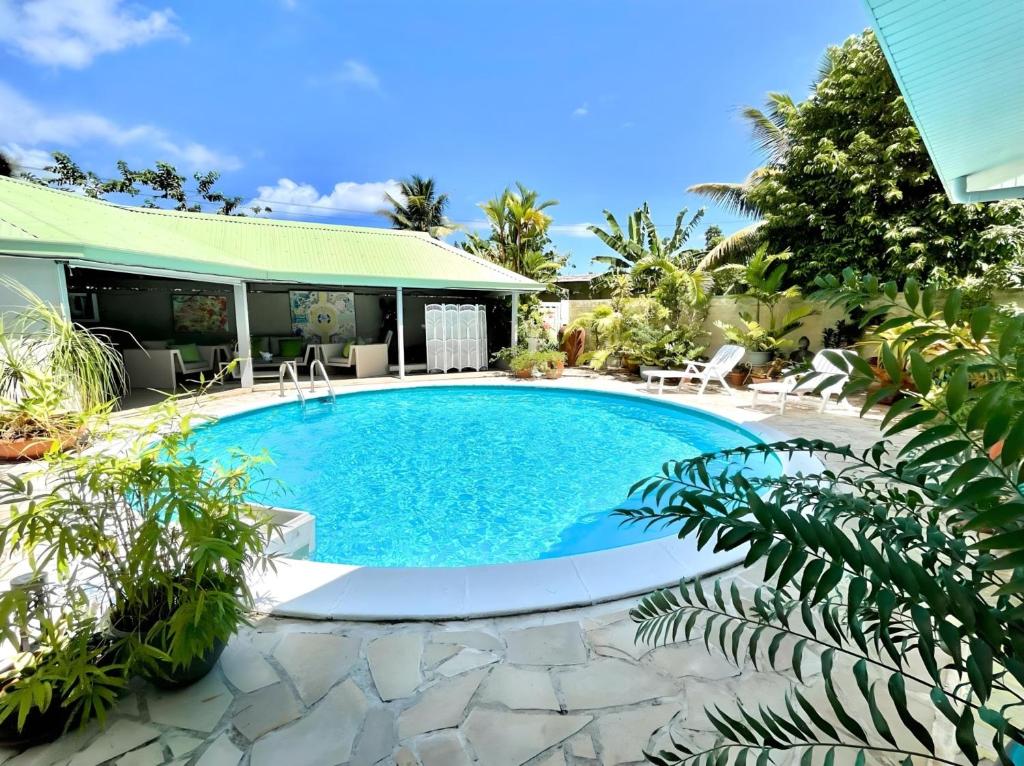 普纳奥亚Tiaki Guesthouse - Cozy Modern Studio - 5min drive from the beach and Punaauia center的一座房子后院的游泳池
