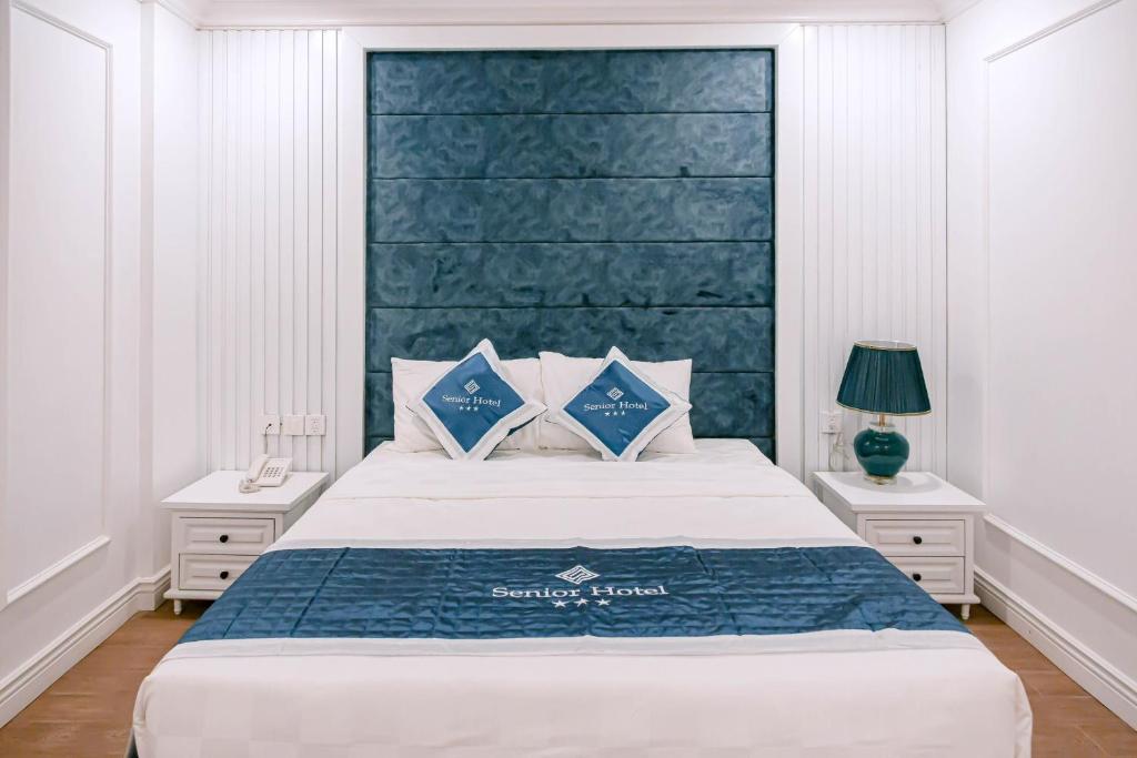 芹苴Senior Hotel的一间卧室配有一张大床和蓝色床头板