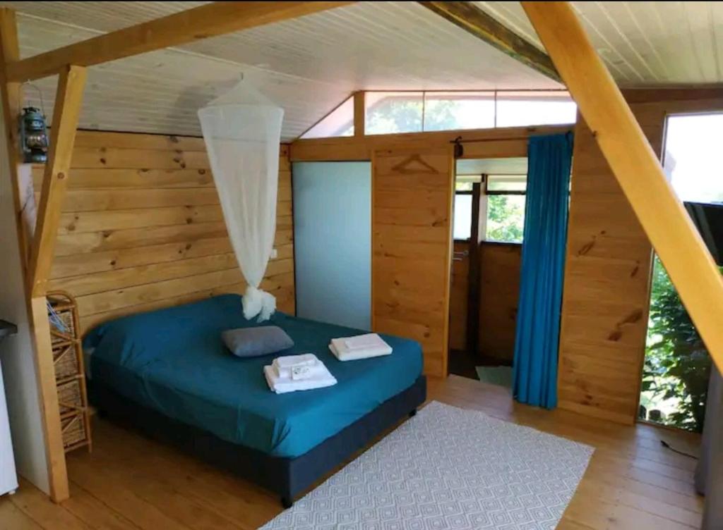 普纳奥亚Bungalow Moemoea的一间设有蓝色床的卧室,位于带木墙的房间
