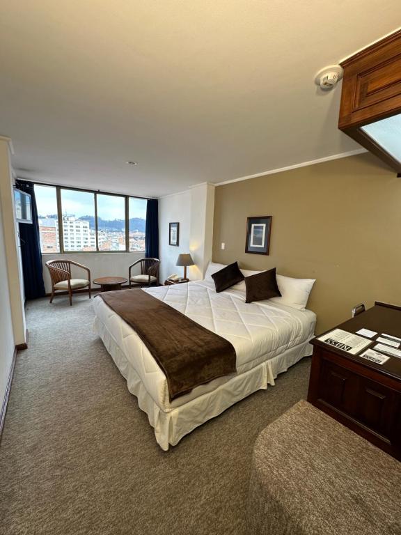 昆卡Hotel Presidente by NASS的一间卧室设有一张大床和一个大窗户
