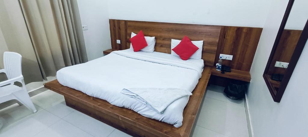 古尔冈The Grace Residency的一张带红色枕头的床