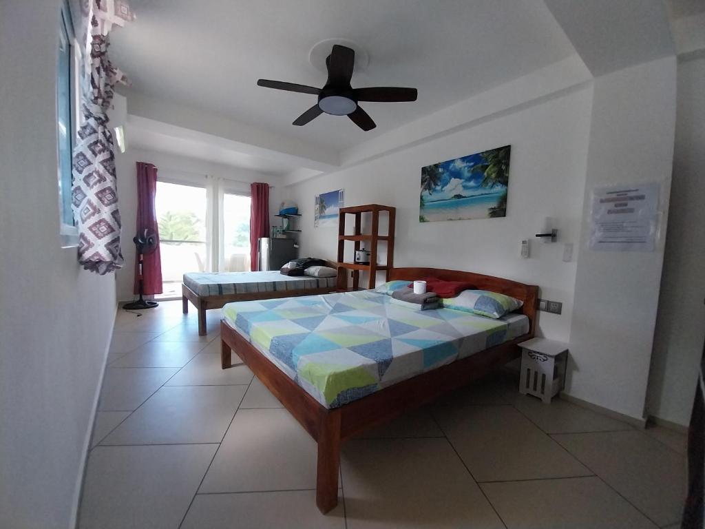 FerrolOlivers Binucot-Beach-House的一间卧室配有一张床和吊扇